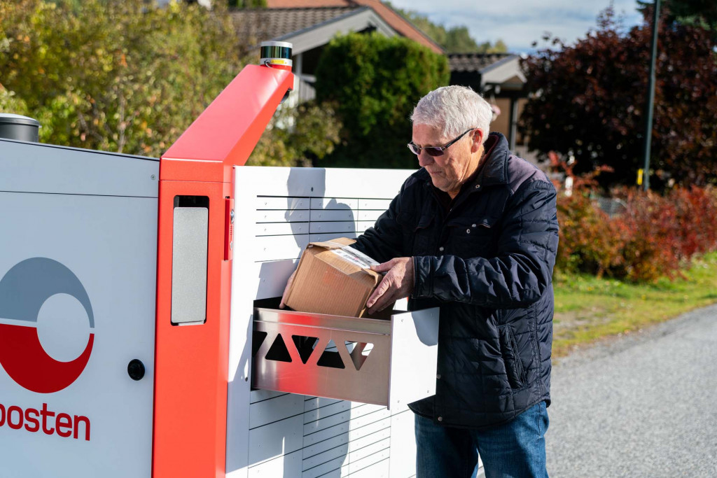 Ein Kunde wirft Post in das mobile Postfach ein.