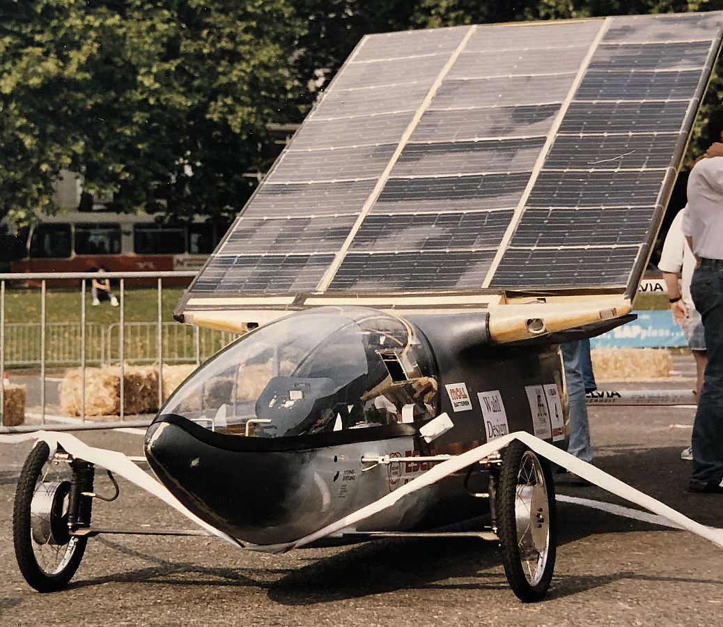 A solar vehicle with a large solar cell in the rear, angled towards the sky.